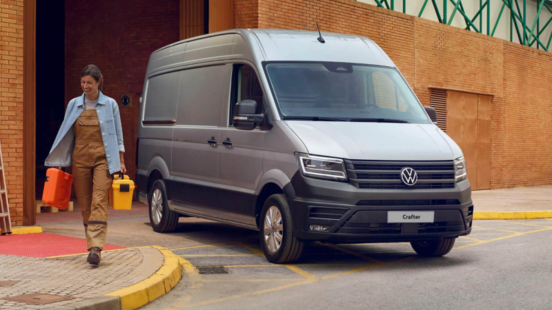 VW Crafter panel van parked outside of a warehouse with a person walking next to it.