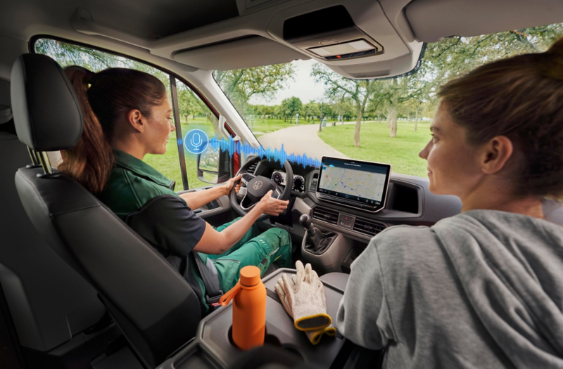 El VW Nuevo California aparcado en la orilla junto a dos personas.