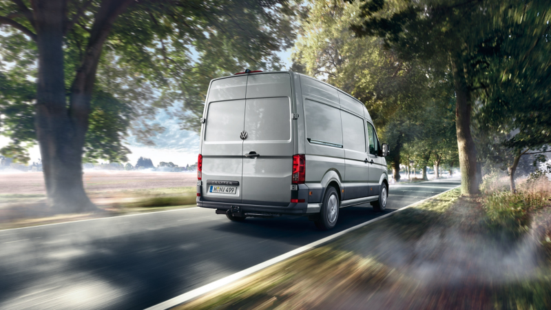 Ein VW Crafter fährt auf einer Landstraße.