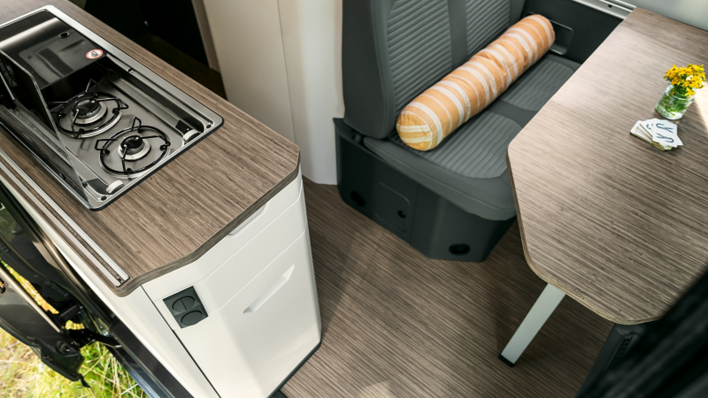Das Interieur des VW Grand Californias mit Küche und Sitzecke.