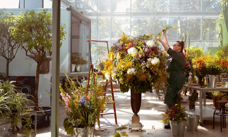 Eine Floristin setzt ein riesiges Bouquet aus Blumen zusammen.