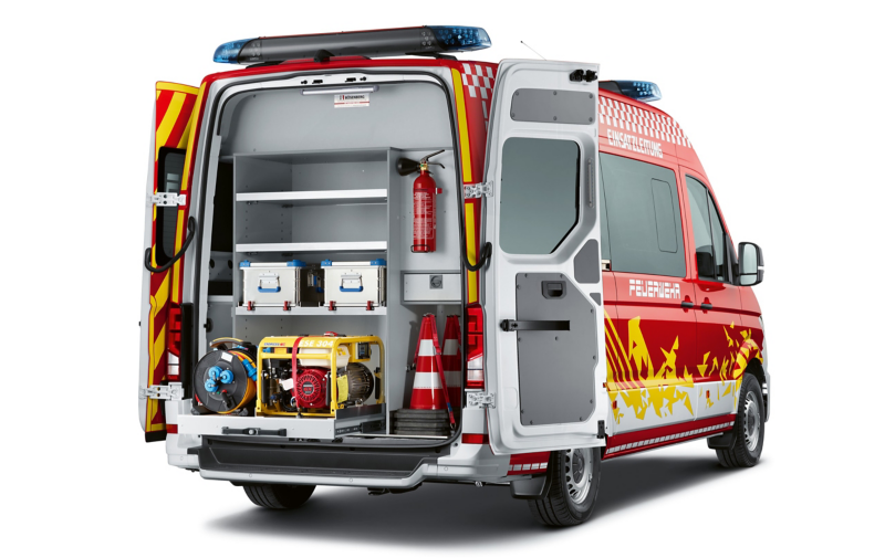 Ein zu einem Einsatzfahrzeug der Feuerwehr umgebauter VW Crafter von hinten mit geöffneten Hecktüren.