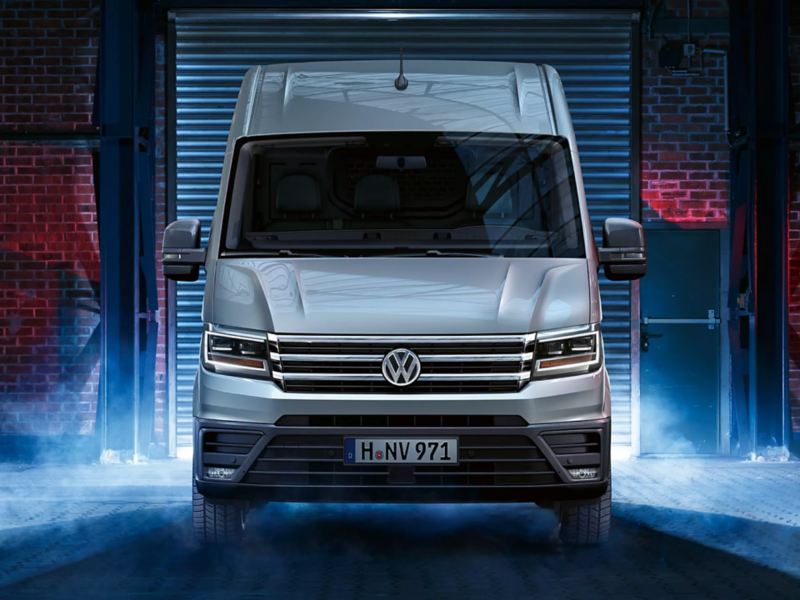 A Volkswagen Crafter Van's tail lights light up as it's turned on and prepares to leave a warehouse