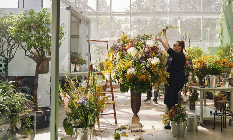 Eine Floristin setzt ein riesiges Bouquet aus Blumen zusammen.