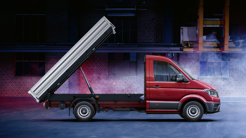 Ein roter VW Crafter mit Kipperaufbau in einer Lagerhalle.