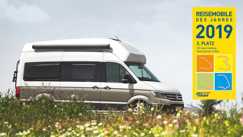 Der Grand California fährt durch Wissen voll Wildblumen. Auf dem Bild ist das Logo des Resemobile des Jahres 2019 Logo mit dem Vermerk „3. Platz“ zu sehen. 