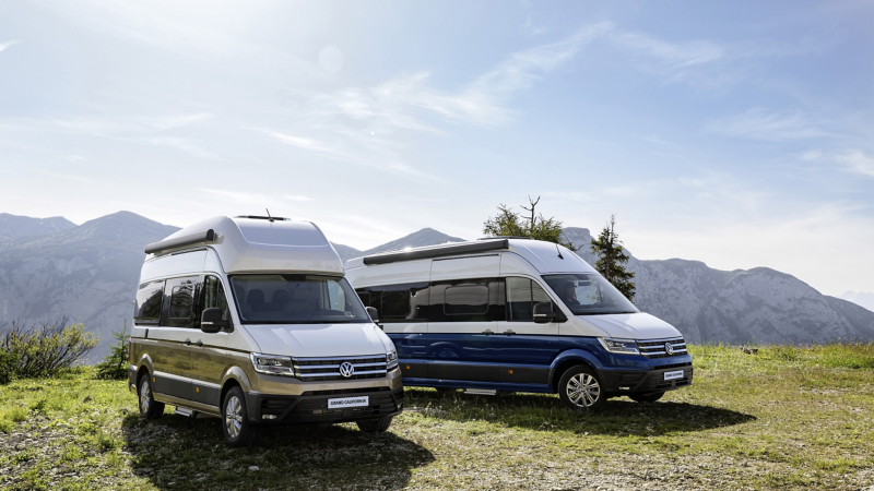 Dwa Volkswageny Grand California na tle górskiego krajobrazu.