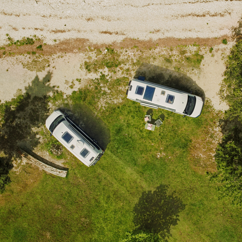 Fågelperspektiv av två VW Grand California husbilar. Grand California 600 kommer med ett mindre solsystem på framsidan av taket, medan ett större solsystem finns i mitten av taket på Grand California 680..