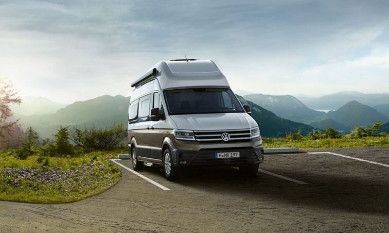 un Grand California VW sur un parking en montagne