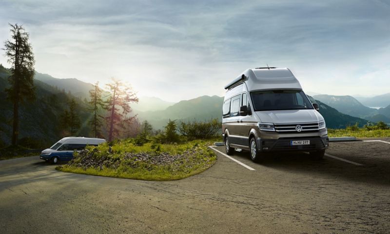 2 Grand California Volkswagen Véhicules Utilitaires sur une route et parking en montagne