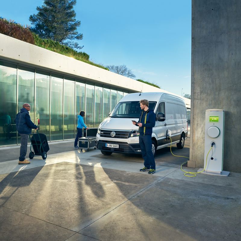 Un Volkswagen e-Crafter dans une situation de tous les jours, à une station de recharge. 
