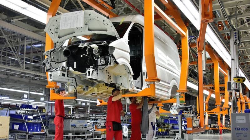 châssis Crafter VW soulevé sur une chaîne de production dans un hangar d'usine