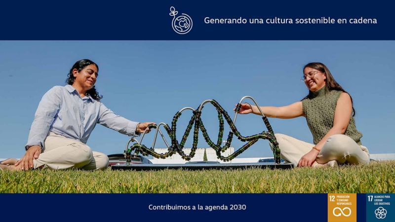 Mujeres observan escultura hecha con botellas de vidrio recicladas.