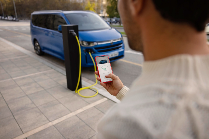 El VW Nuevo California aparcado en la orilla junto a dos personas.