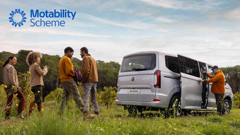 A group of people in a flowery meadow with a Transporter Shuttle closeby