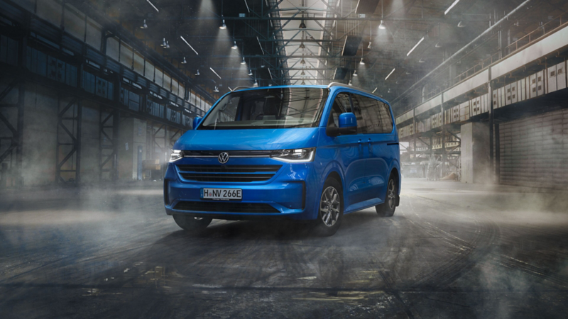 Caravelle VW bleue vue de face 3/4 dans un entrepôt