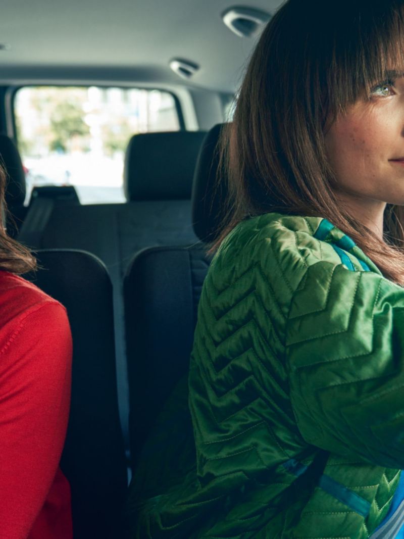 Zwei Frauen sitzen im Fahrgastraum der VW Caravelle 6.1.