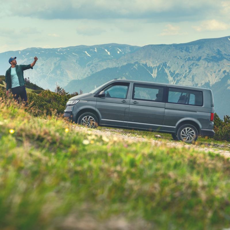 Ein VW Caravelle vor einer Berglandschaft.