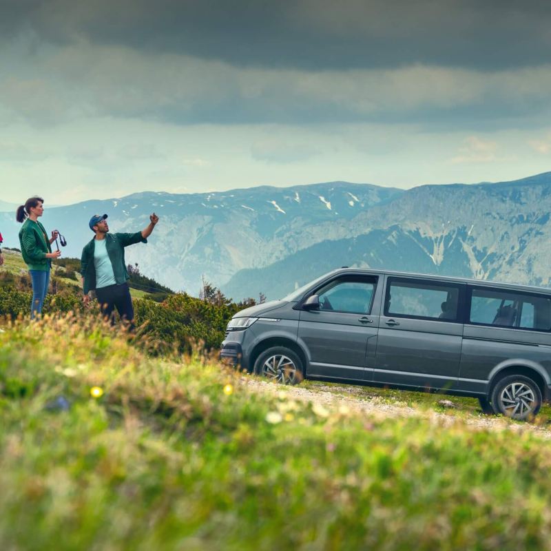 Ein VW Caravelle vor einer Berglandschaft.