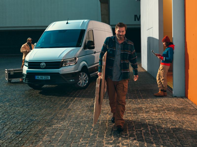 Eine kleine Gruppe von Menschen um den VW Crafter Kastenwagen EcoProfi.