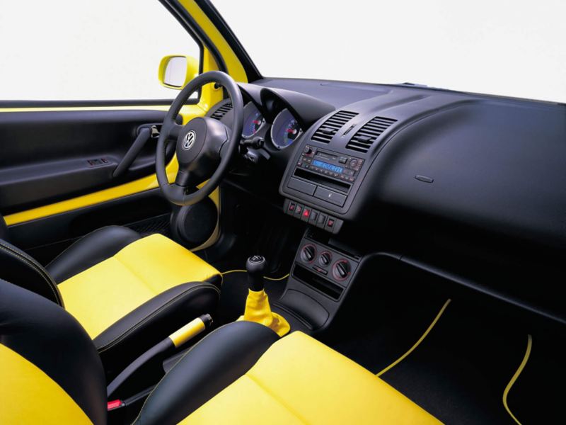 Habitacle, sellerie colorée jaune, et planche de bord de la VW Lupo.