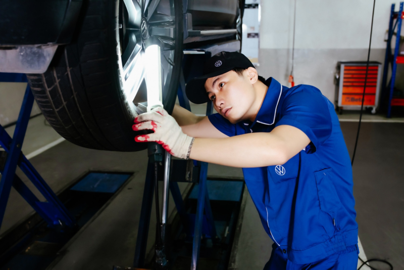 Nhân viên dịch vụ ngồi trên chồng lốp xe ô tô 