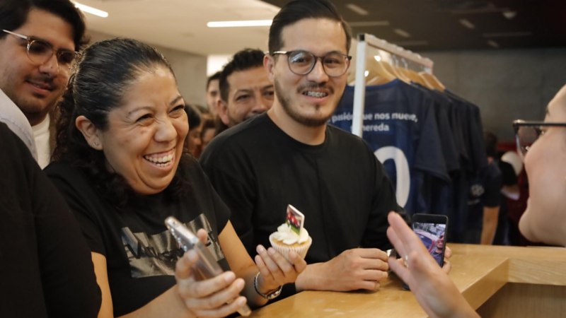 Hombre sonríe mientras sostiene cupcake decorado durante evento de Volkswagen.