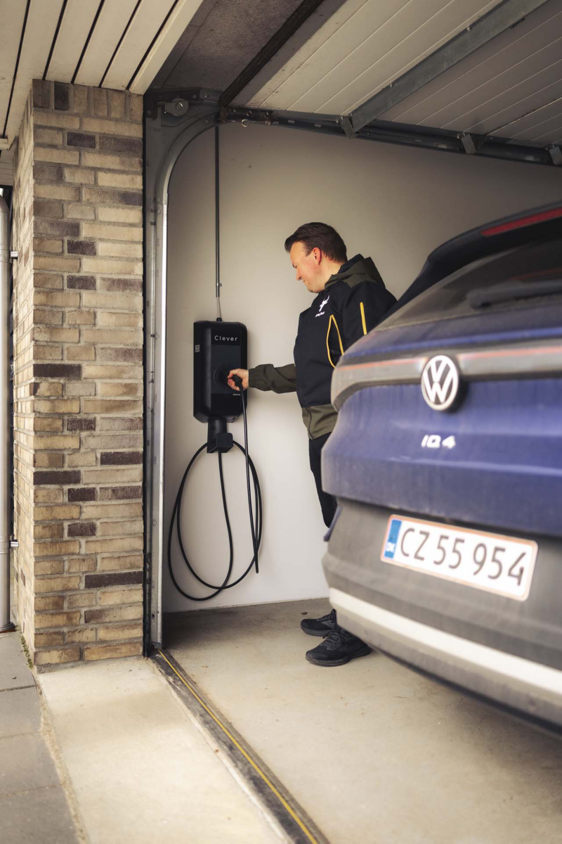 Morten sætter ladestik tilbage i ladeboks i hans garage