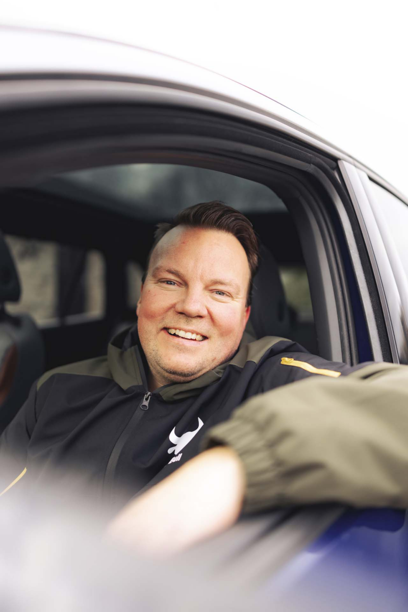 Morten sidder og smiler med armen ude af det åbne vindue på sin bil