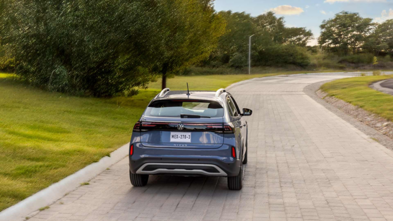 Camioneta SUV de Volkswagen circula sobre un camino adoquinado y rodeado de área verde. 
