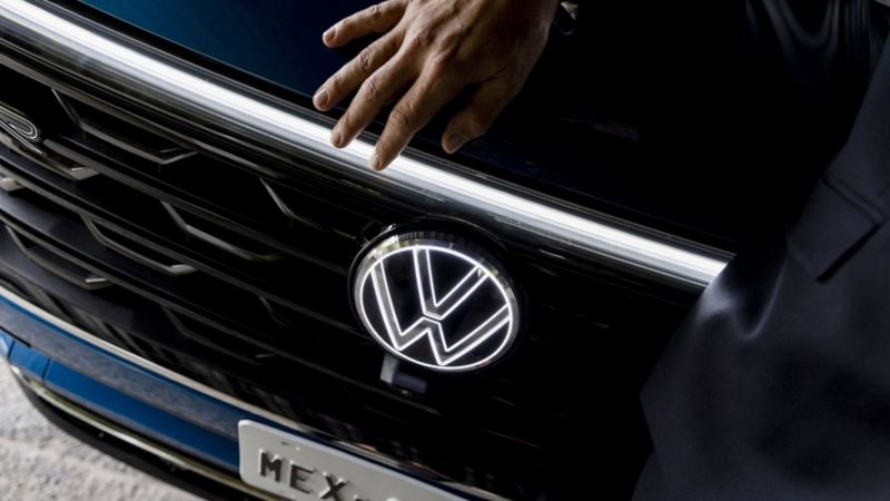 Logo de VW y labio superior de parrilla iluminados en camioneta de lujo Cross Sport de Volkswagen.