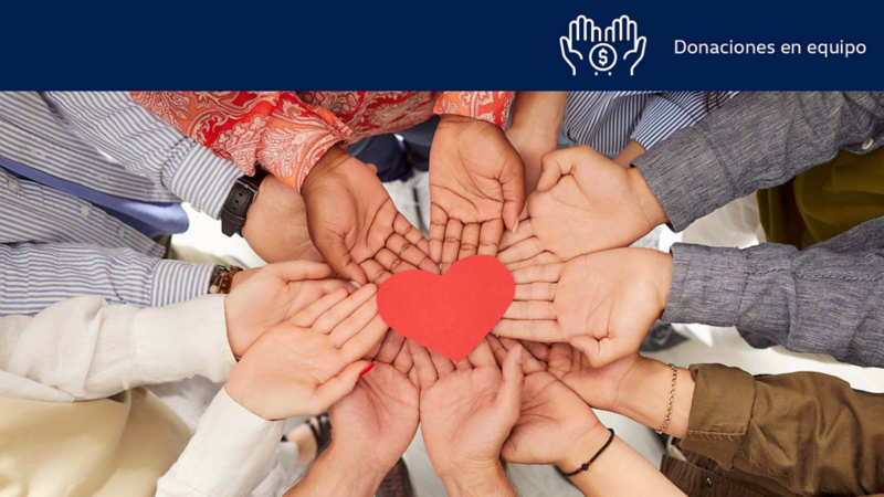 Manos de personas sostienen un corazón de papel. 