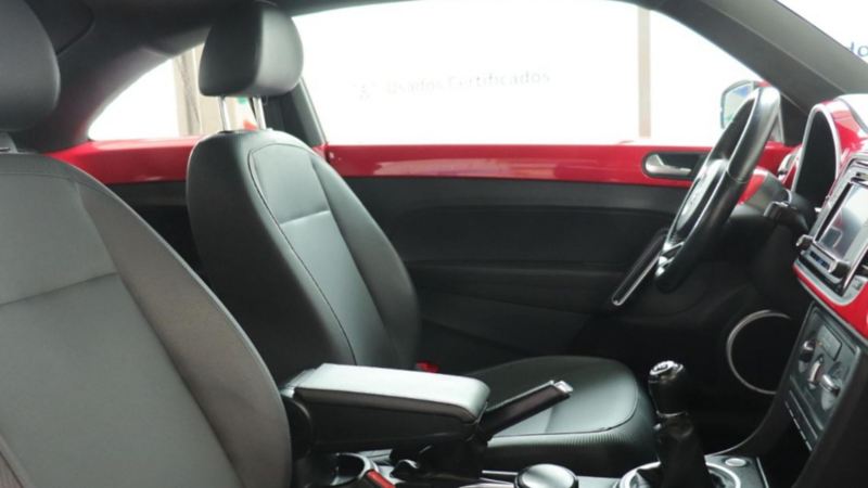 Interior de Volkswagen Beetle con asientos forrados en tonalidad negra.