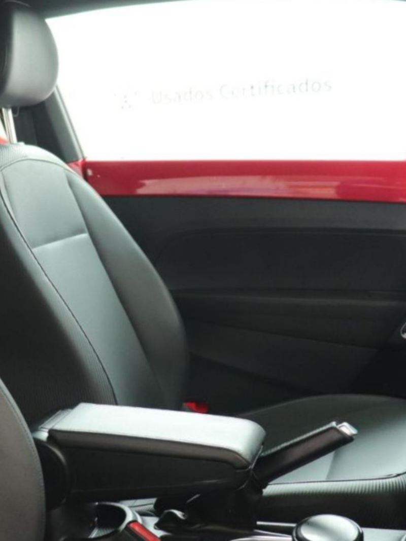 Interior de Volkswagen Beetle con asientos forrados en tonalidad negra.