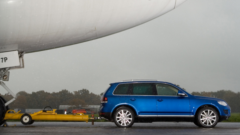 Un VW Touareg bleu remorque un Boeing 747 de 155 tonnes portant l’inscription « Touareg ».