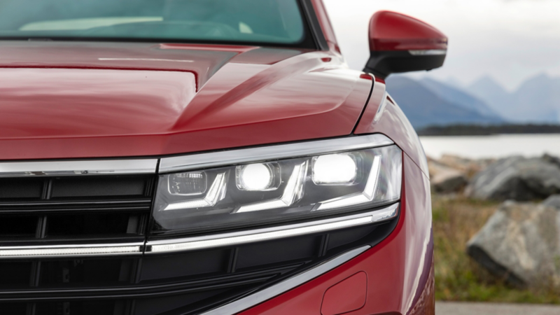 Gros plan sur les phares avant matriciels LED d’un VW Touareg rouge.