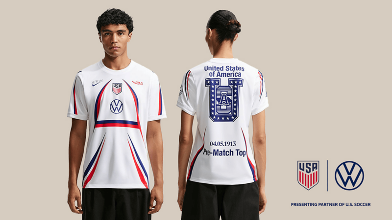 Camiseta de calentamiento de la selección de fútbol de Estados Unidos, con diseño blanco, detalles en rojo y azul y el logotipo de Volkswagen.