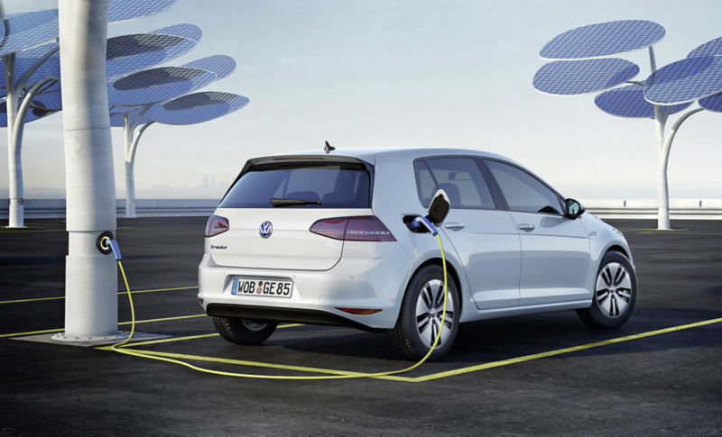 Vit Volkswagen e-Golf sedd bakifrån står parkerad vid en laddstation