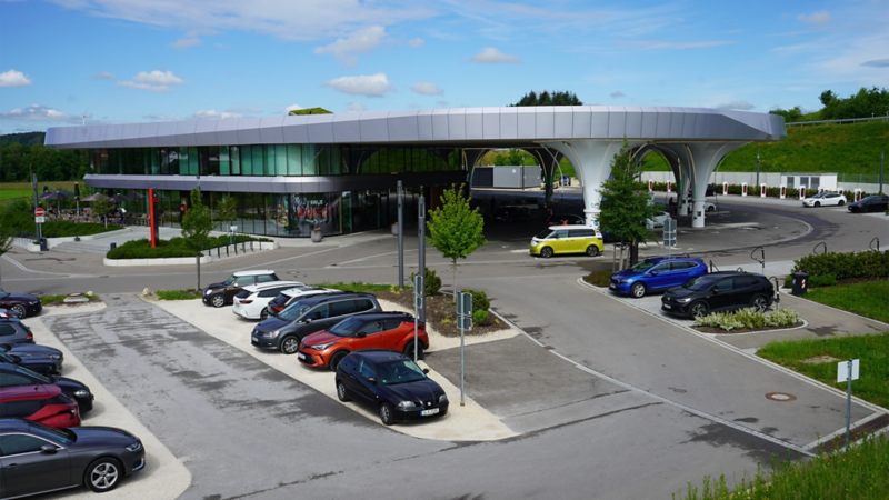 Diverse auto parcheggiate presso una futuristica stazione di ricarica