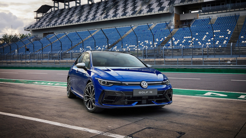 A woman leans against her blue VW Golf R