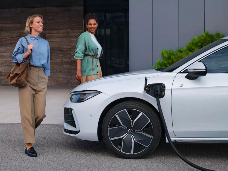 Deux femmes passent devant la VW Passat en charge.