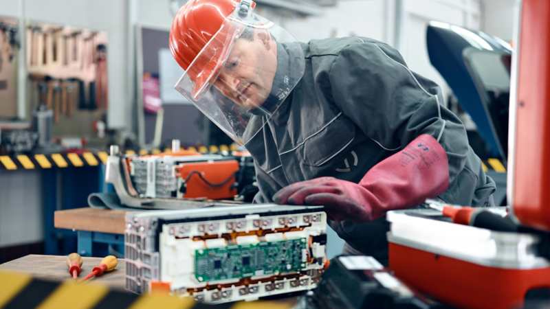 Ein Ingenieur mit einer Autobatterie