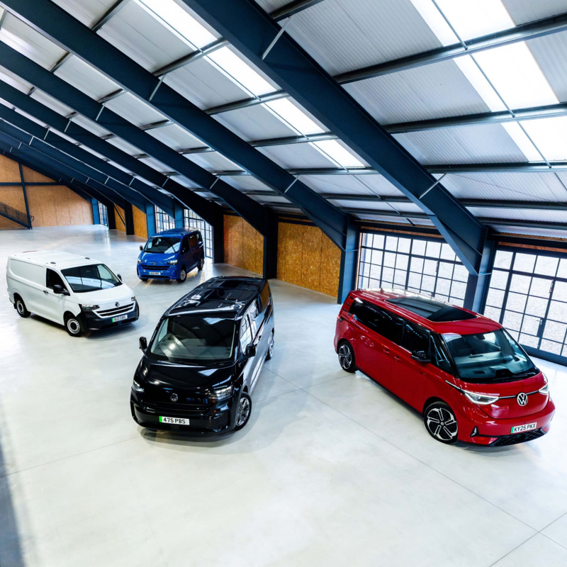 Volkswagen all-electric vans: ID. Buzz Cargo, e-Transporter Panel van, e-Transporter Kombi and e-Transporter Shuttle parked in a warehouse with dark metal panels overheard
