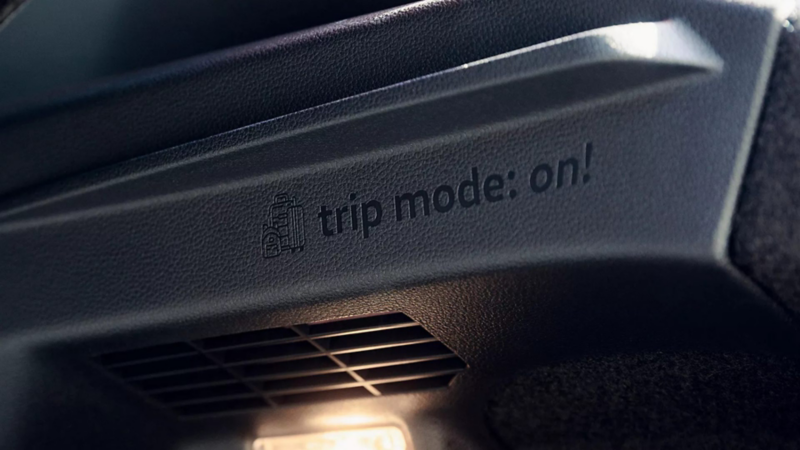 Detalle "trip mode: on!" con ícono de equipaje en el interior de Tera 2026, función para viajes.