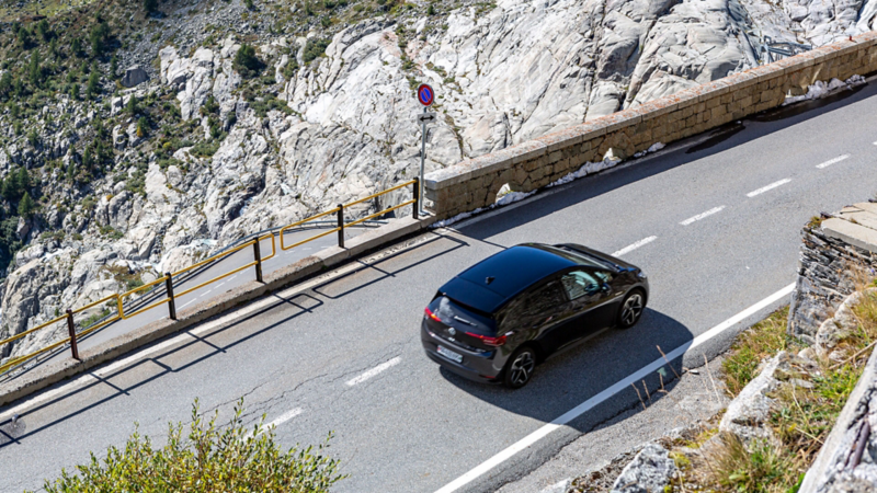 ID.3, seitlich von hinten und von etwas weiter oben, fährt auf einer Pass-Strasse
