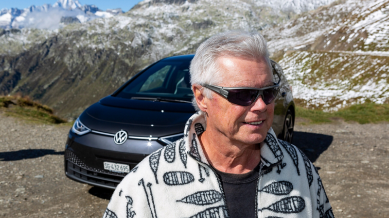 Felix Egolf  und der ID.3 im Hintergrund in den Alpen