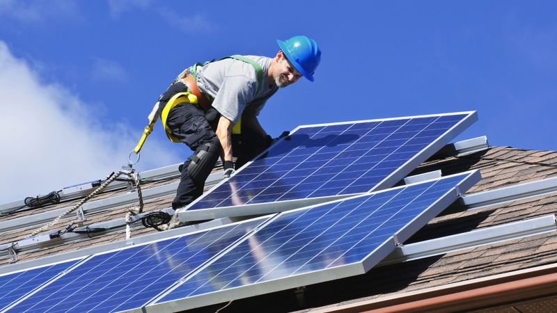Eine Photovoltaikanlage wird auf einem Dach installiert.