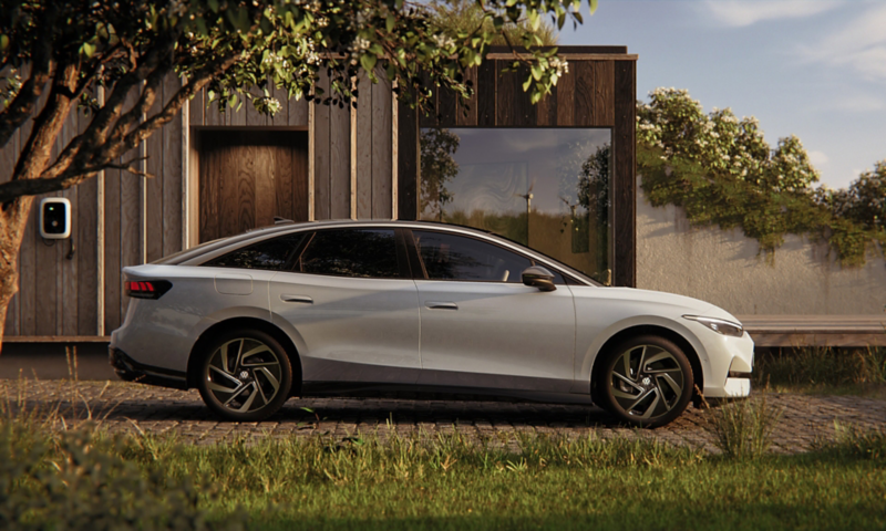 A VW ID.7 is parked in front of a house. Side view of the vehicle.