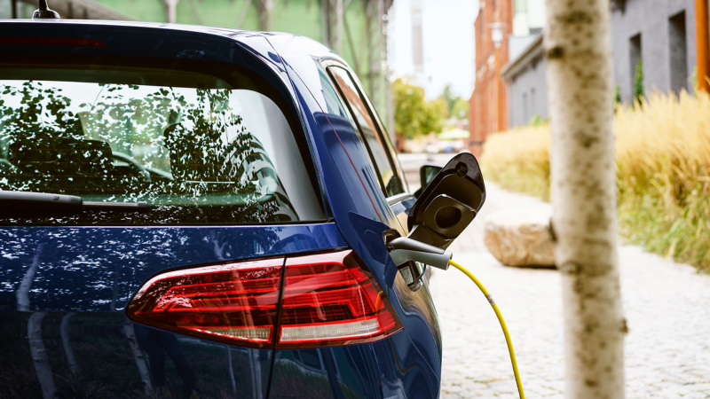 a blue VW car plugged in charging