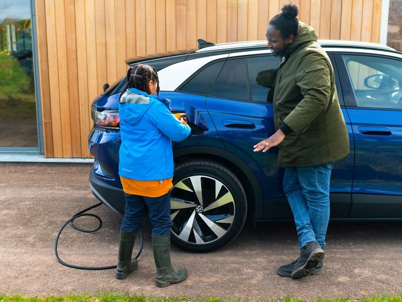 A mother and child charging an electric VW vehicle
